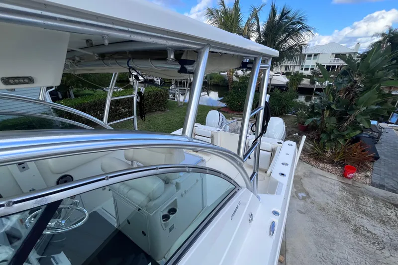 Slide: The Image of 2010 World Cat 290 EC boat docked near tropical plants and waterfront homes. - 34