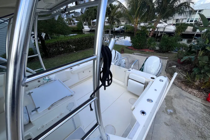 Slide: The Image of 2010 World Cat 290 EC boat interior with dual engines, docked near lush greenery. - 35
