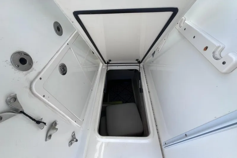 Slide: The Image of 2010 World Cat 290 EC boat storage compartment with open hatch and visible interior. - 43