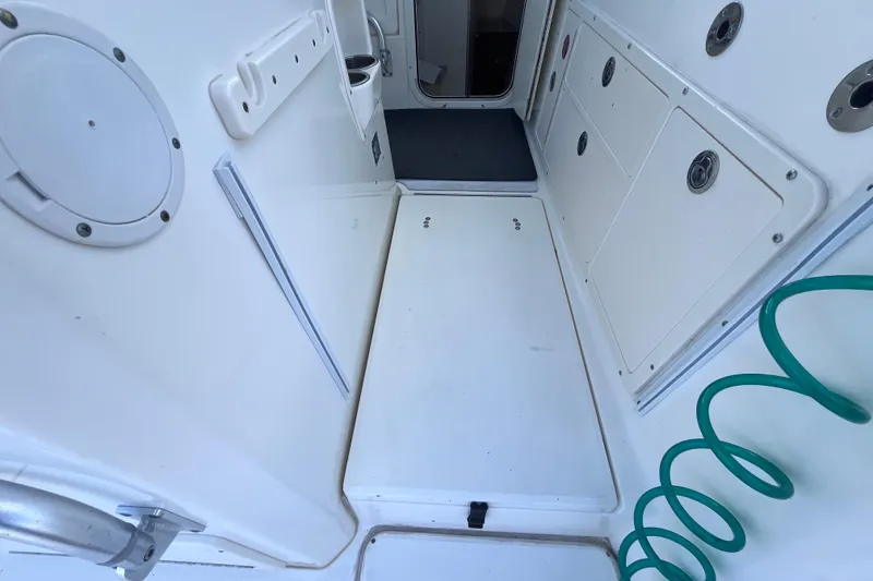 Slide: The Image of 2010 World Cat 290 EC boat interior with storage compartments and coiled hose. - 45