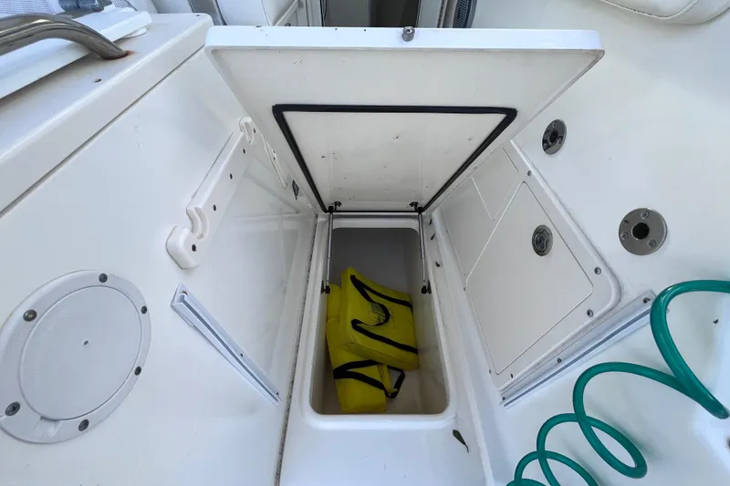 Slide: The Image of Open storage compartment on 2010 World Cat 290 EC boat with yellow bag inside. - 46