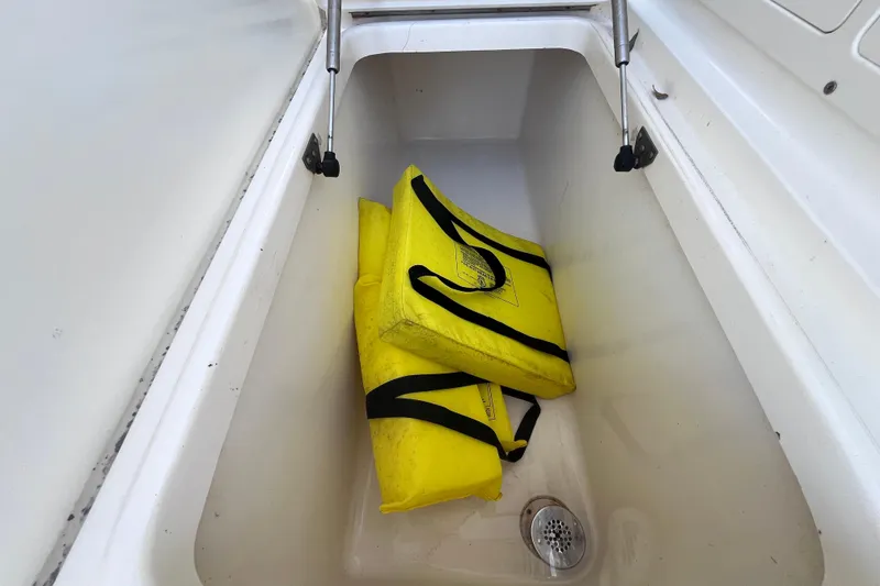 Slide: The Image of Yellow life jackets in storage compartment of 2010 World Cat 290 EC boat. - 47