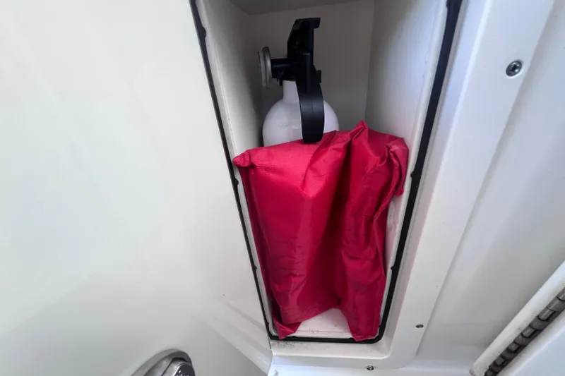 Slide: The Image of Storage compartment on 2010 World Cat 290 EC boat with fire extinguisher and red life jacket. - 52