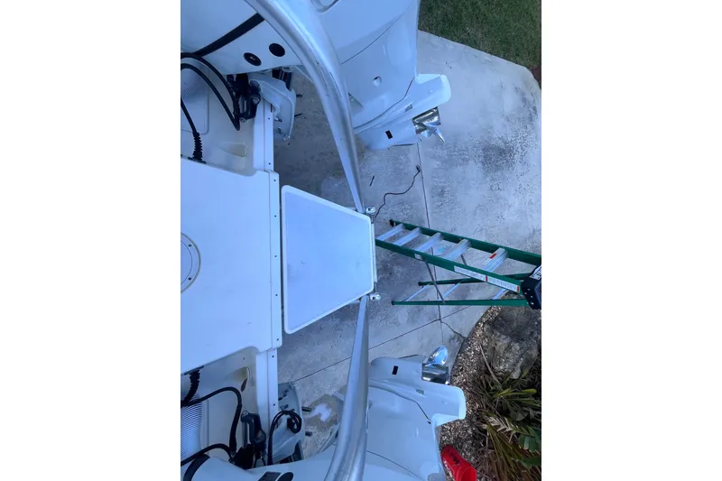 Slide: The Image of 2010 World Cat 290 EC boat with dual engines, viewed from above, near a green ladder. - 63