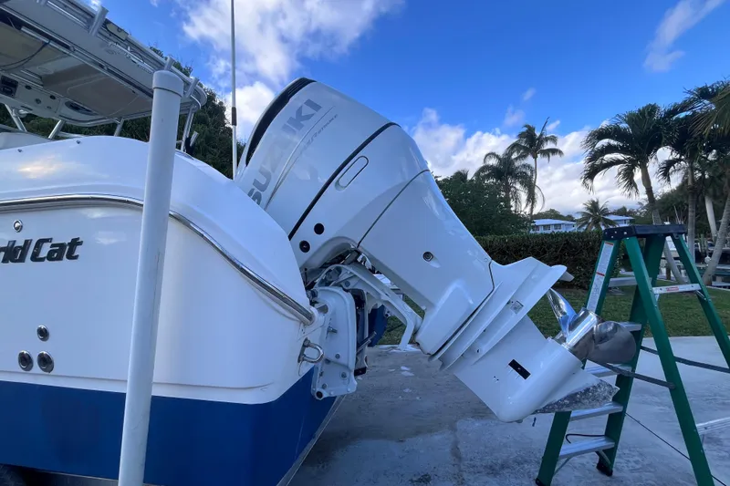 Slide: The Image of 2010 World Cat 290 EC boat with Suzuki outboard motor, parked outdoors under blue sky. - 66