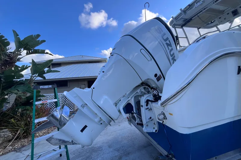 Slide: The Image of 2010 World Cat 290 EC boat with Suzuki outboard motor, parked near a house. - 68