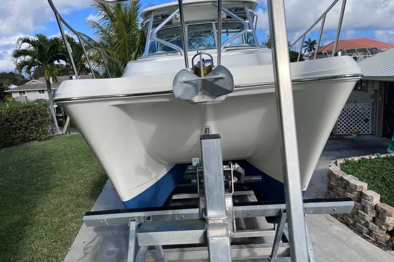 Slide: The Image of 2010 World Cat 290 EC boat on trailer, parked in a residential driveway. - 8