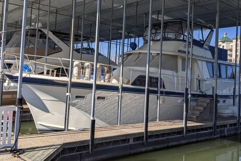 The Image of 1984 Hatteras 53 Extended Deckhouse Motor Yacht docked in a covered marina. - 0