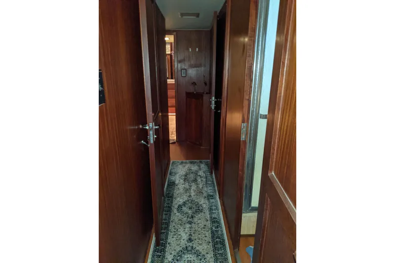 Slide: The Image of Hallway inside 1984 Hatteras 53 Extended Deckhouse Motor Yacht with wooden doors and carpet. - 17