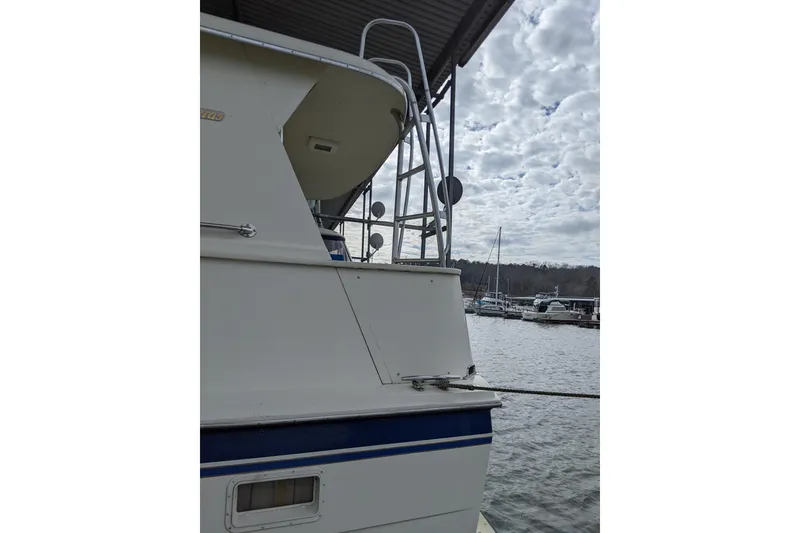 Slide: The Image of 1984 Hatteras 53 Extended Deckhouse Motor Yacht docked under cloudy sky. - 2