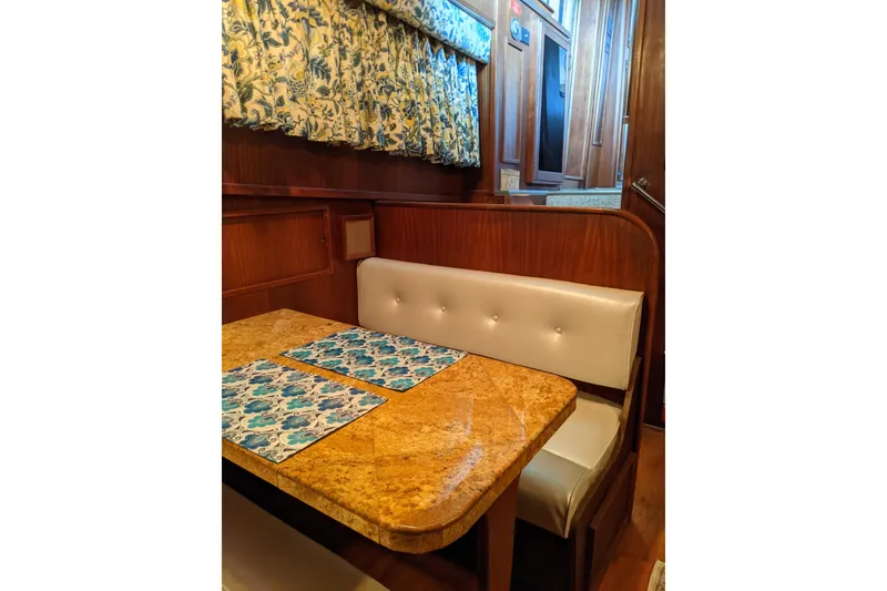 Slide: The Image of Interior of 1984 Hatteras 53 Motor Yacht with elegant dining area and floral decor. - 24