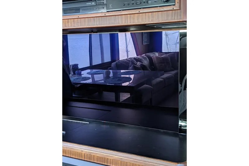 Slide: The Image of Interior of 1984 Hatteras 53 Yacht, featuring a reflective TV screen and cozy seating area. - 32