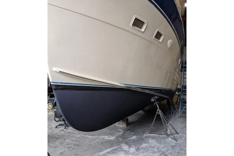Slide: The Image of 1984 Hatteras 53 Extended Deckhouse Motor Yacht in dry dock, showcasing hull and portholes. - 46