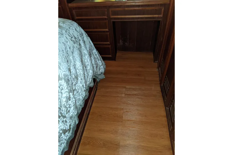Slide: The Image of Interior of 1984 Hatteras 53 Motor Yacht with wood flooring and elegant bedding. - 53