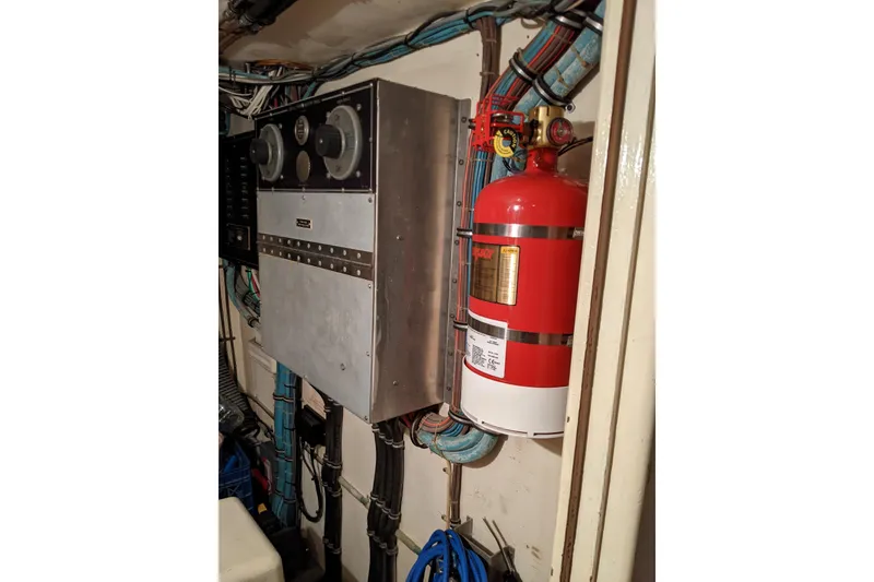 Slide: The Image of Engine room of 1984 Hatteras 53 Motor Yacht with fire extinguisher and control panel. - 70