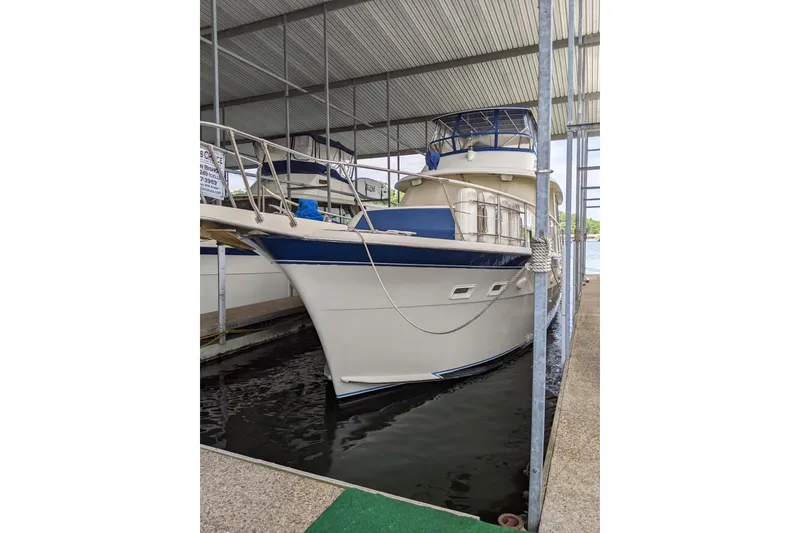 Slide: The Image of 1984 Hatteras 53 Extended Deckhouse Motor Yacht docked under a covered marina. - 85