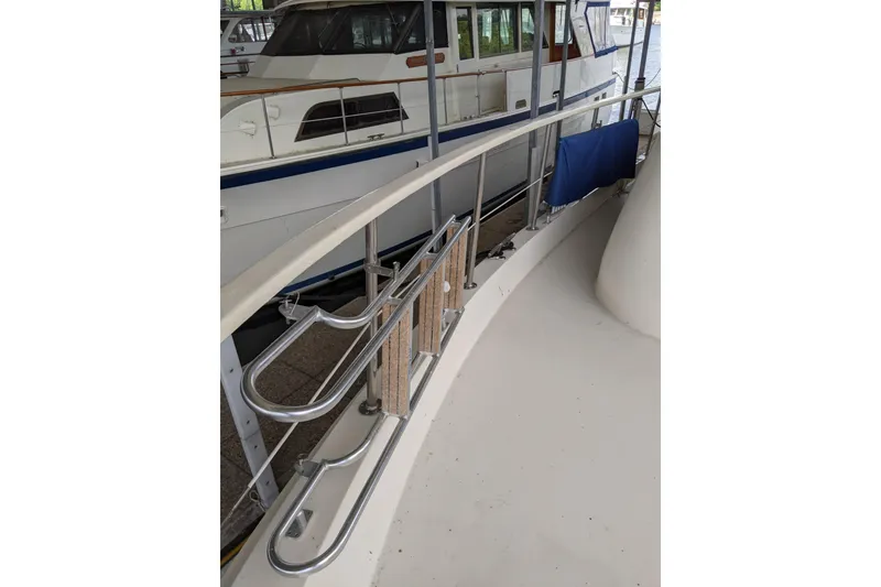 Slide: The Image of 1984 Hatteras 53 Extended Deckhouse Motor Yacht, featuring sleek railings and spacious deck area. - 90