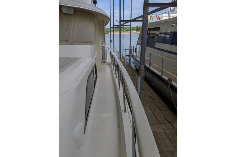 Slide: The Image of 1984 Hatteras 53 Extended Deckhouse Motor Yacht docked beside another boat. - 91