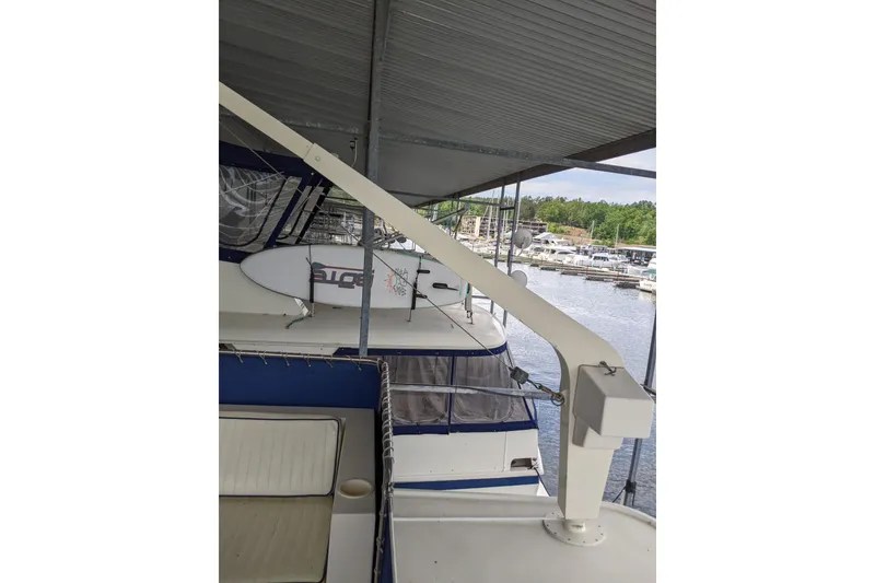 Slide: The Image of 1984 Hatteras 53 Extended Deckhouse Motor Yacht docked under a covered marina. - 97
