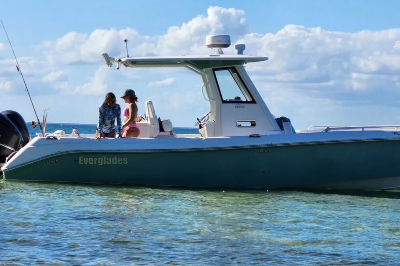 The Image of 2012 Everglades 295 Center Console boat on clear water with two people onboard. - 1