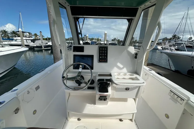 Slide: The Image of 2012 Everglades 295 Center Console boat helm with steering wheel and control panel. - 12