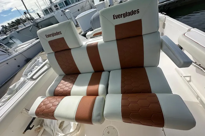 Slide: The Image of 2012 Everglades 295 Center Console boat seats with brown and white upholstery. - 16