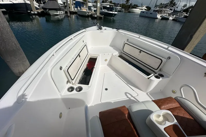 Slide: The Image of 2012 Everglades 295 Center Console boat interior at marina, featuring storage compartments. - 6