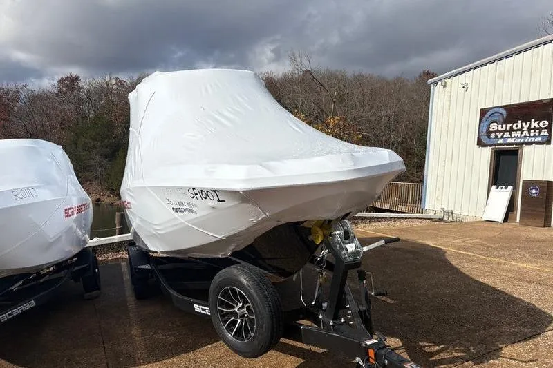 Slide: The Image of 2026 Scarab 255 Open LX Wake boat covered, parked outside Surdyke Yamaha Marina. - 3