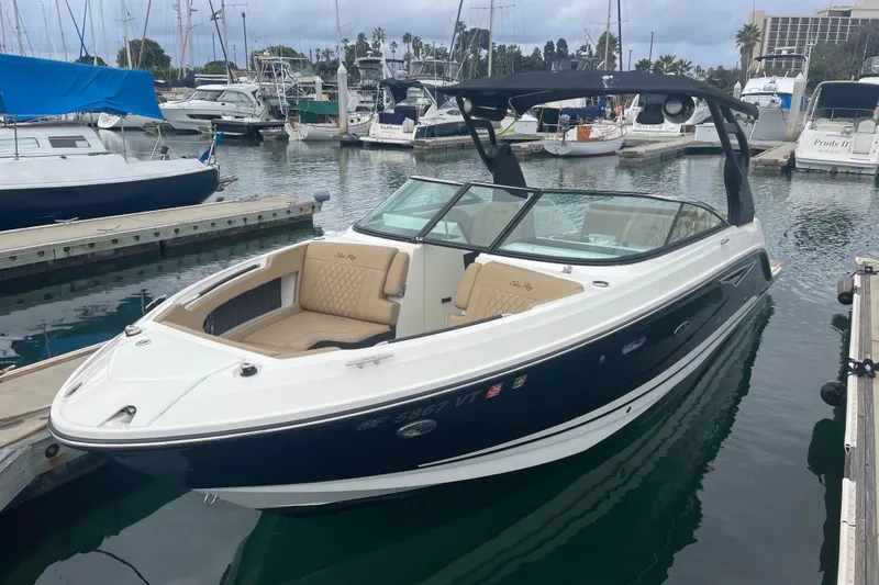 The Image of 2021 Sea Ray SLX 250 boat docked in a marina with other vessels. - 0