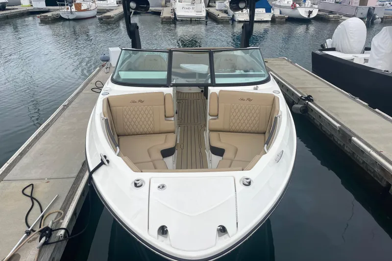 Slide: The Image of 2021 Sea Ray SLX 250 boat docked, featuring luxurious tan seating and sleek design. - 1
