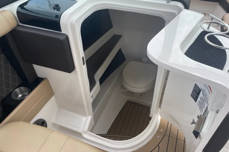 Slide: The Image of 2021 Sea Ray SLX 250 boat interior with compact bathroom and seating area. - 7