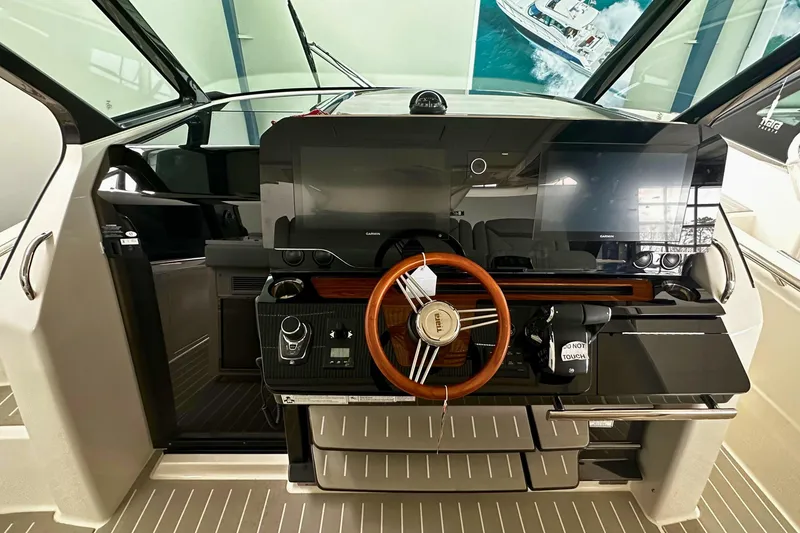 Slide: The Image of 2026 Tiara Yachts 39 LS helm with modern controls and wooden steering wheel. - 29