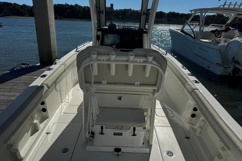 Slide: The Image of 2026 World Cat 235 TE boat interior at dock, featuring seating and rod holders. - 4