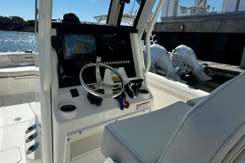 Slide: The Image of 2026 World Cat 235 TE boat cockpit with steering wheel and navigation display. - 7