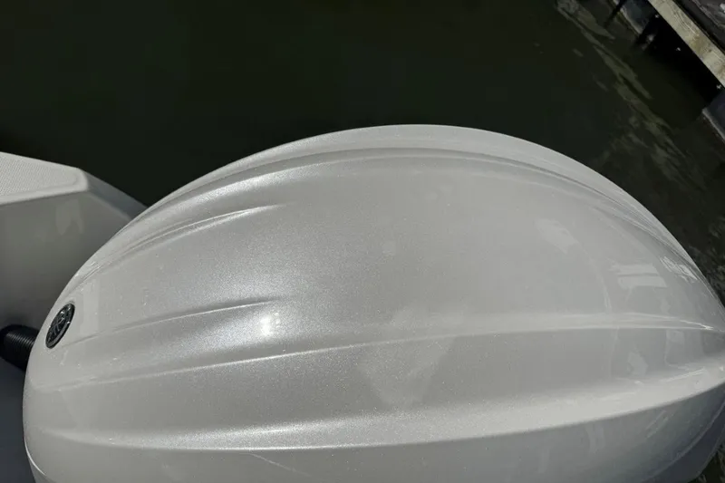 Slide: The Image of Close-up of a 2026 World Cat 235 TE boat's sleek, white exterior on water. - 16
