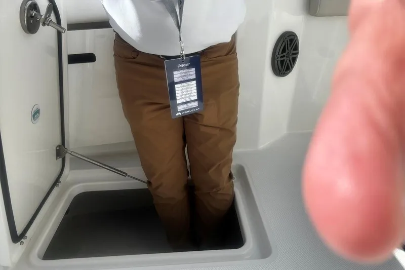 Slide: The Image of Person standing in hatch of 2026 World Cat 235 TE boat interior. - 11