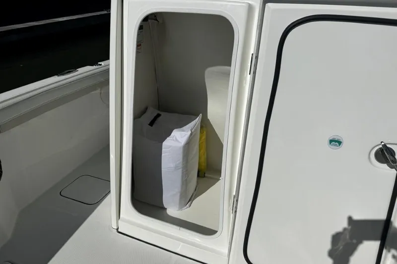 Slide: The Image of Storage compartment on 2026 World Cat 235 TE boat, featuring a white interior and secure door. - 14