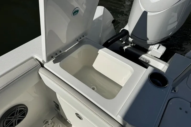 Slide: The Image of Open storage compartment on 2026 World Cat 235 TE boat, near engine and cup holder. - 12