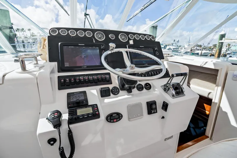 Slide: The Image of Cockpit of 2001 Rampage 38 Express boat with steering wheel and navigation instruments. - 10