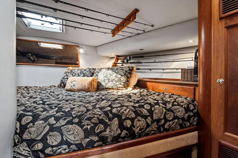 Slide: The Image of Luxurious cabin interior of 2001 Rampage 38 Express with fishing rods and patterned bedding. - 17