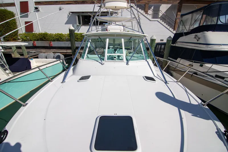 Slide: The Image of 2001 Rampage 38 Express boat docked, showcasing spacious deck and sleek design. - 19