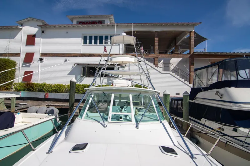 Slide: The Image of 2001 Rampage 38 Express yacht docked near a white building under clear blue skies. - 20