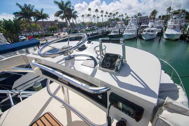 Slide: The Image of Helm of 2001 Rampage 38 Express boat docked at marina with palm trees. - 24