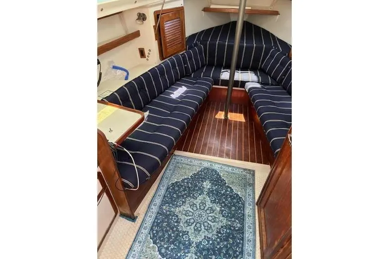 Slide: The Image of Interior of 1995 Catalina 270 sailboat with striped seating and decorative rug. - 2
