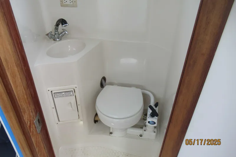 Slide: The Image of Compact bathroom in a 1995 Catalina 270 sailboat, featuring a toilet and sink. - 4