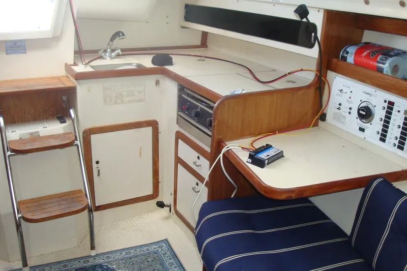 Slide: The Image of Interior of a 1995 Catalina 270 sailboat featuring a compact kitchen and navigation area. - 6