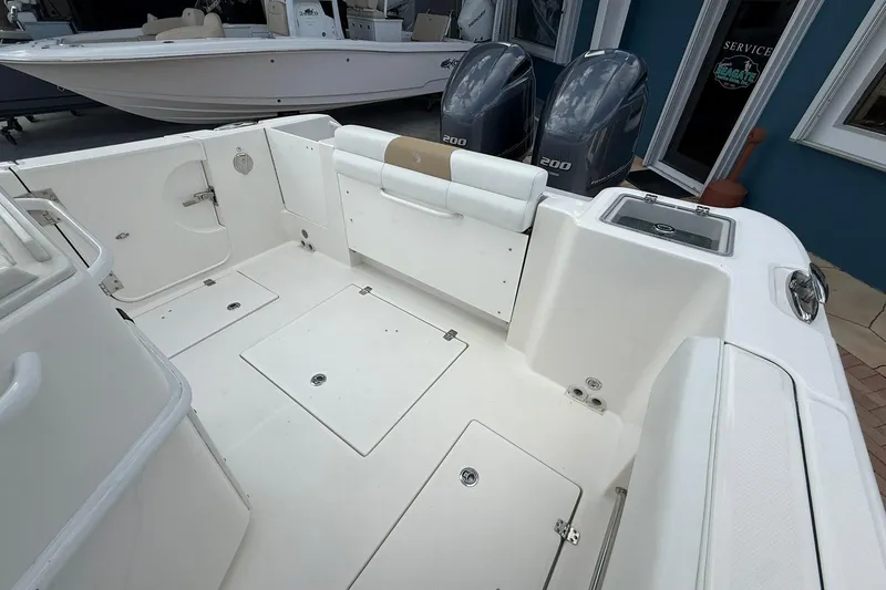Slide: The Image of 2018 Edgewater 262CC boat interior with dual engines and spacious deck layout. - 14
