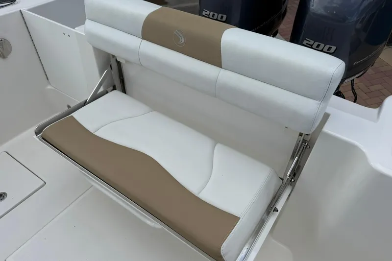 Slide: The Image of 2018 Edgewater 262CC boat seat with beige and white upholstery, dual engines visible. - 15