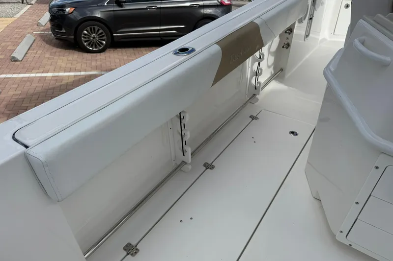 Slide: The Image of 2018 Edgewater 262CC boat interior with white seating and storage compartments. - 16