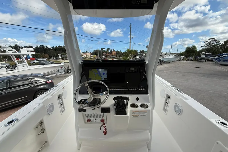 Slide: The Image of 2018 Edgewater 262CC boat cockpit with steering wheel and navigation system. - 18